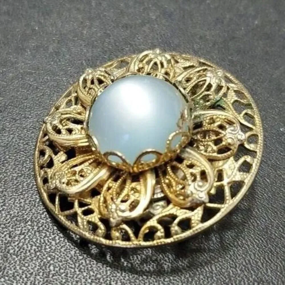 Vintage gold tone round brooch with blue